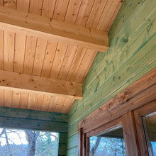 Load image into Gallery viewer, Detailed view of the wooden ceiling and beams of the cabin's porch, showcasing the natural wood finish and craftsmanship by WholeWoodCabins