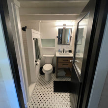 Load image into Gallery viewer, Cabin bathroom with white toilet, sink, shower and vanity area.