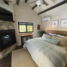 Load image into Gallery viewer, Cabin bedroom with king size bed, fireplace, tv, fan and large window
